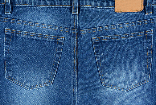 Close up of blue denim jeans back pockets