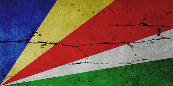 Seychelles Flag on cracked wall background.