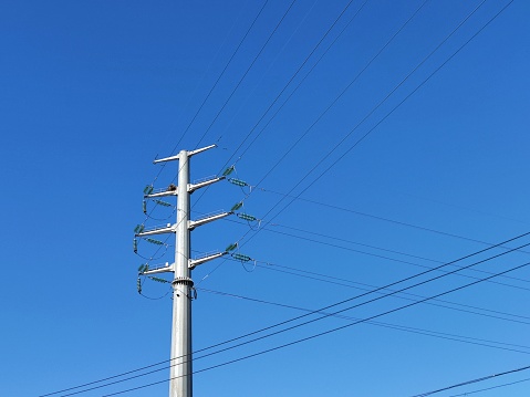 Telephone pole with vibrant blue sky.