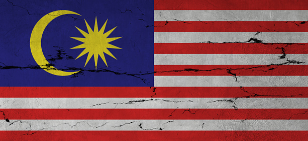 Malaysian Flag on cracked wall background.