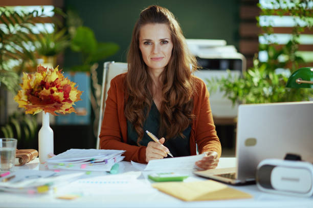 stylish small business owner woman in modern green office stock photo