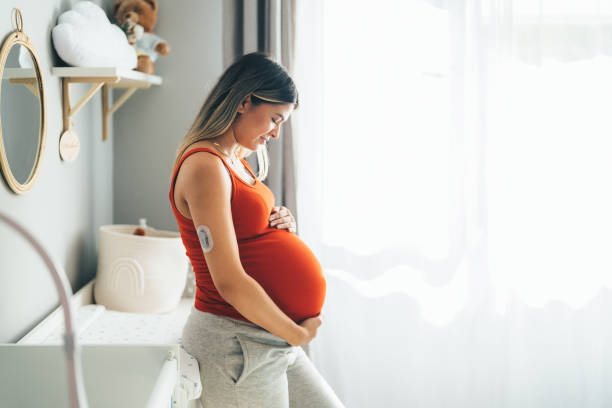 pregnant young woman with diabetes at home feeling excited about her firstborn - human pregnancy prenatal care women abdomen imagens e fotografias de stock