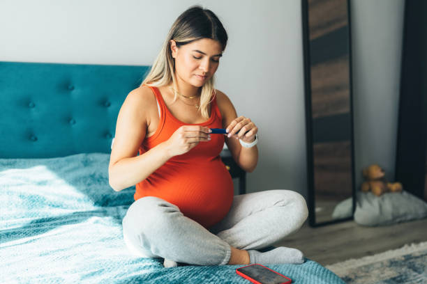 Pregnant young woman injecting insulin with insulin pen stock photo