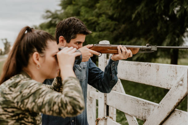 kobieta i mężczyzna polowanie na dżinsy i kamuflaż - hunting two people camouflage rifle zdjęcia i obrazy z banku zdjęć