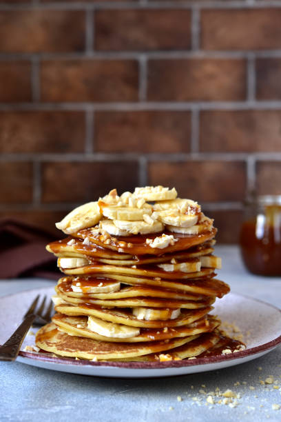 istock Hot pancakes with banana, nuts  and caramel sauce. 1436144268