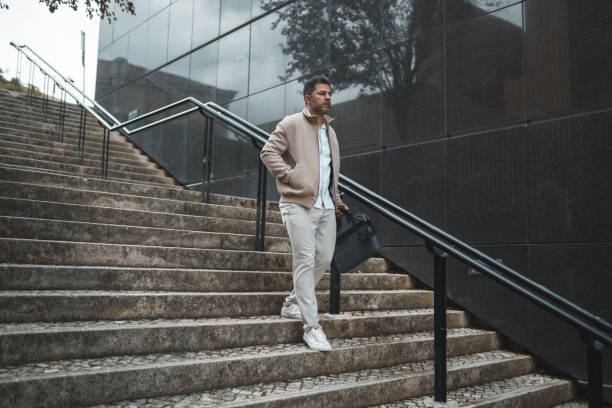 istock Business man walking down the stairs 1436144362