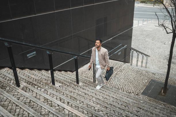 istock Business man walking up the stairs 1436144364