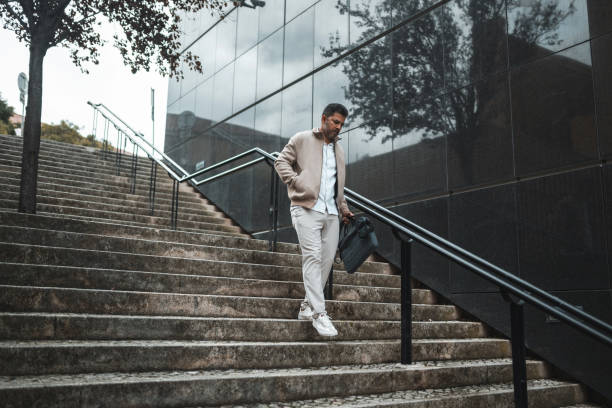 istock Business man walking down the stairs 1436144510