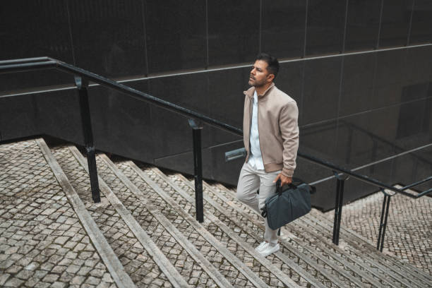 istock Business man walking up the stairs 1436144512