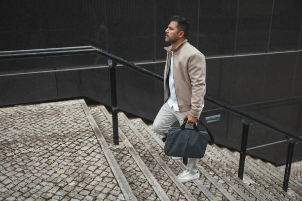 istock Business man walking up the stairs 1436144617