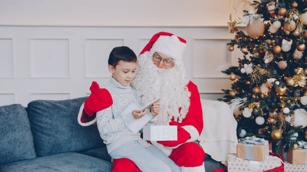 istock kid unpacking Santa's present and getting smartphone on holiday 1436144743