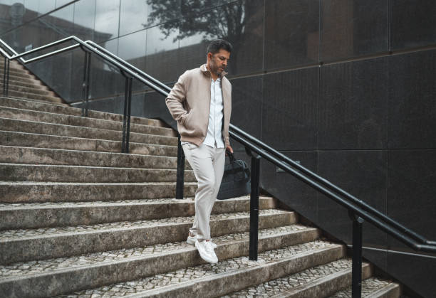 istock Business man walking down the stairs 1436144746