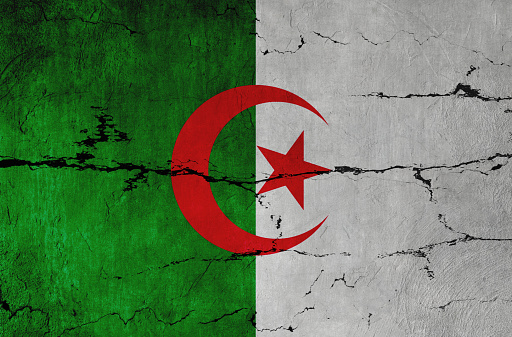 Algerian Flag on cracked wall background.