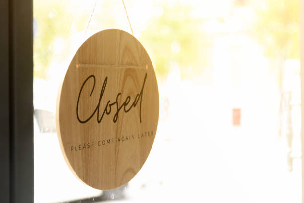 Sign of Closed and Please come again later wording on wooden board. stock photo