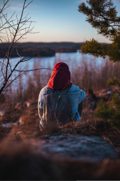 istock lonely man sitting and looking at sunset behind a river dramatic and loneliness, 1436148113