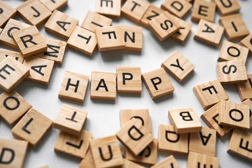 There are a lot of square wooden cubes with letters creating the word Happy around. greeting wish card. High quality Horizontal photo Greetings for March 8 and Valentine's Day, new year, sign to be happy, dont worry, Happy game night. Leisure activities
