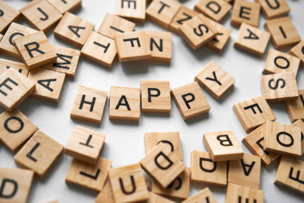 Word happy spelled in wooden blocks in the center on a white light gray background. There are a lot of square wooden cubes with letters around. greeting wish card. High quality Horizontal photo There are a lot of square wooden cubes with letters creating the word Happy around. greeting wish card. High quality Horizontal photo Greetings for March 8 and Valentine's Day, new year, sign to be happy, dont worry, Happy game night. Leisure activities word game stock pictures, royalty-free photos & images