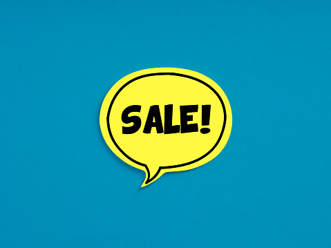 The word sale on yellow speech bubble on blue background. Business shopping discount or promotion announcement concept.