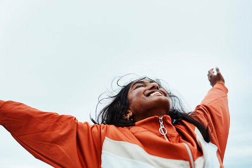 Happy black woman, freedom and sky for success in adventure, travel or achievement in the outdoors. Female celebrating goal being free in nature for successful traveling to India in joyful happiness