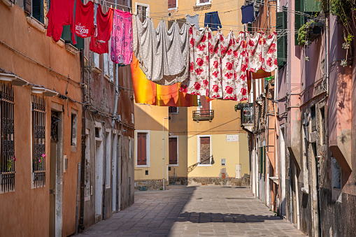 Group of towels and bathrobes hanging outside the window on a clothesline to dry in the sun. Tellaro village, Liguria, Italy, southern Europe.