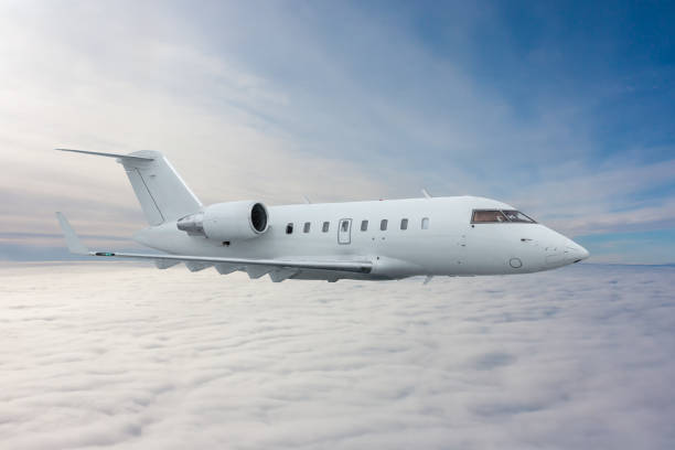 istock White private jet fly in the air above the clouds 1436157755