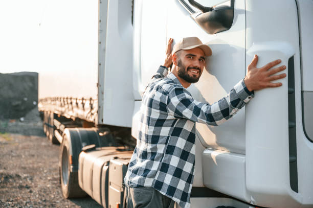 istock Embracing his vehicle. Young truck driver is outdoors at day time 1436158949