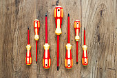 Screwdrivers. A set of bright colored screwdrivers on a wooden background. Repair and renovation concept.