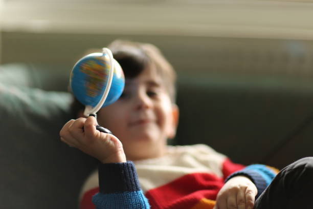 istock Young boy looking at globe in bedroom 1436159431