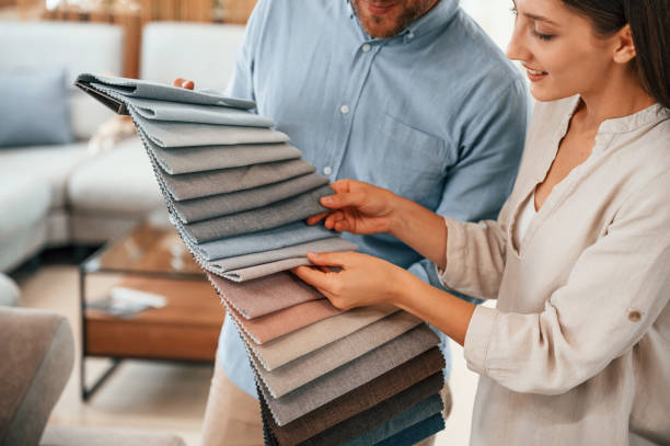 istock Man holding different colored materials to choose from. Couple looking for the sofa and bed in the store 1436159793