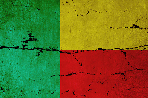 Benin Flag on cracked wall background.