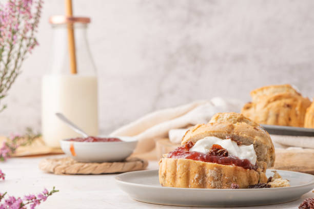 homemade raisin scones with clotted cream and strawberry jam ready to eat - treated wood imagens e fotografias de stock