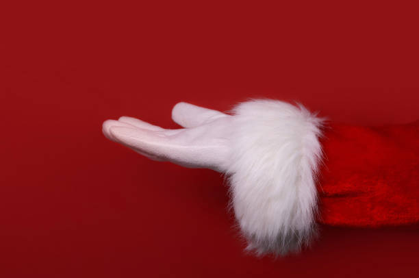 istock Santa Claus hand presenting your text, product, advertisement on a red background.Mockup. Copy space. 1436162972