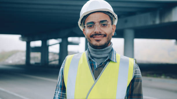 istock Joyful Arab guy wearing construction uniform standing in urban building area smiling 1436165219