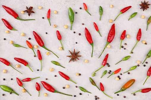 Chili powder and dried chilli in spoon on marble background, cayenne pepper.