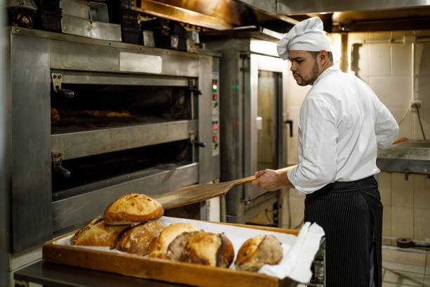 istock Baker taking the breads out of the oven 1436167404