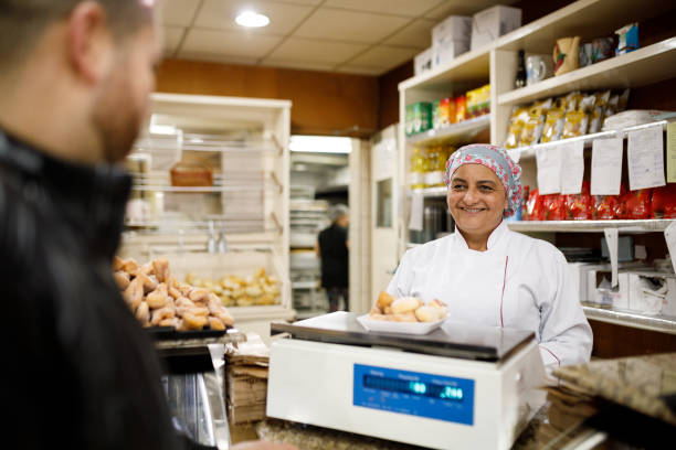istock Woman weighing food for customer 1436167532