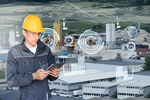 Engineer with digital tablet on a background of modern smart factory. Digital transformation and industry 4.0