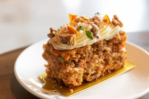 Carrot cake with walnuts, prunes and dried apricots with little edible flower. stock photo