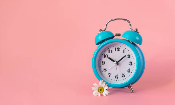istock Blue alarm clock on pink background 1436170062