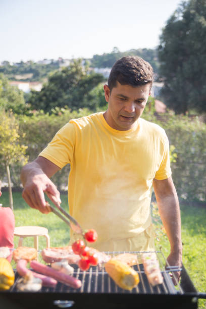 istock Pleased mid adult man grilling steak and corn 1436171632