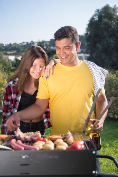 istock Pleased father grilling meat and vegetables with daughter 1436171640