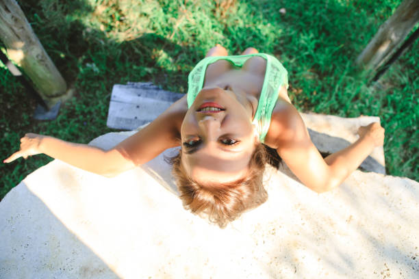 Woman lying on the grass near sunbed with book