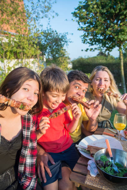istock Merry family sitting around table at backyard 1436171727