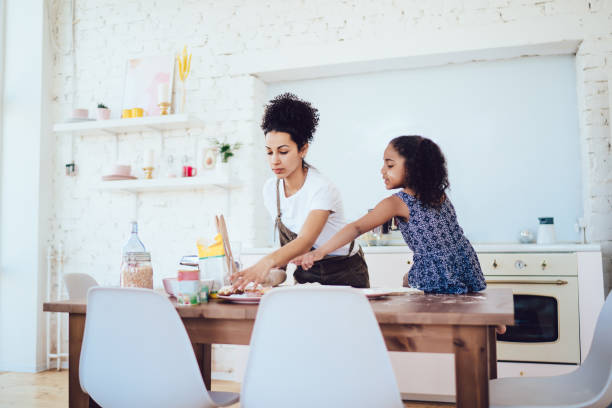 istock Black mother taking cookie for daughter 1436171838