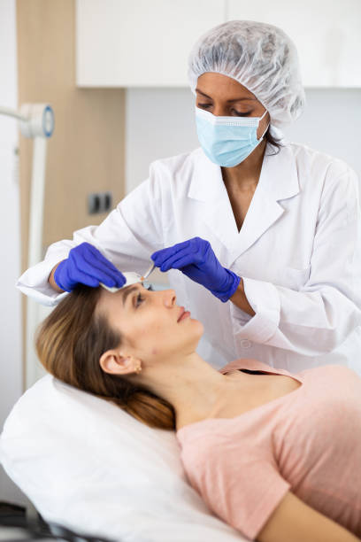 istock Cosmetologist using pencil for marking skin of patient 1436176046