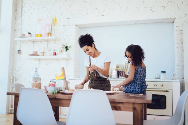 istock Cheerful mother and daughter preparing pastry together 1436176280