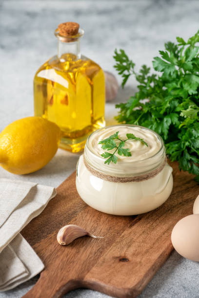 istock Aioli sauce with ingredients on a wooden cutting board. Side view, selective focus. Vertical image. Homemade mayonnaise. 1436176312