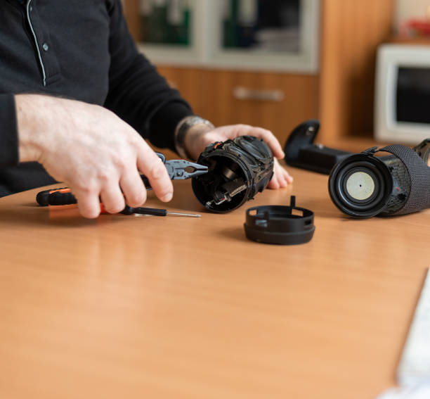 istock a man in the office repairs a portable Bluetooth speaker 1436176803