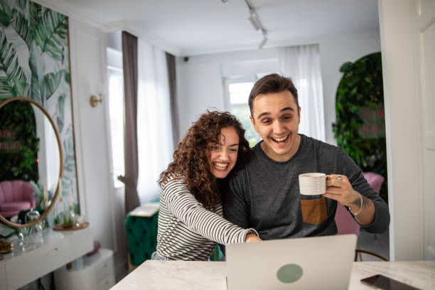 istock Happy couple in love drinking morning coffee and using laptop 1436180178