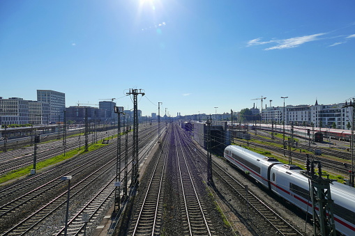 Railway track system of the Munich city main terminal station with 32 platforms. At the background you can see the silhouette of the Frauenkirche (Cathedral of Our Dear Lady).